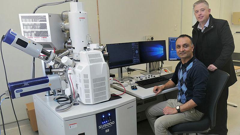 Defence Science and Technology Group's Ben Barona, right, and Shyam Mehta with a field emission scanning electron microscope purchased as part of the Capital Refresh Program.