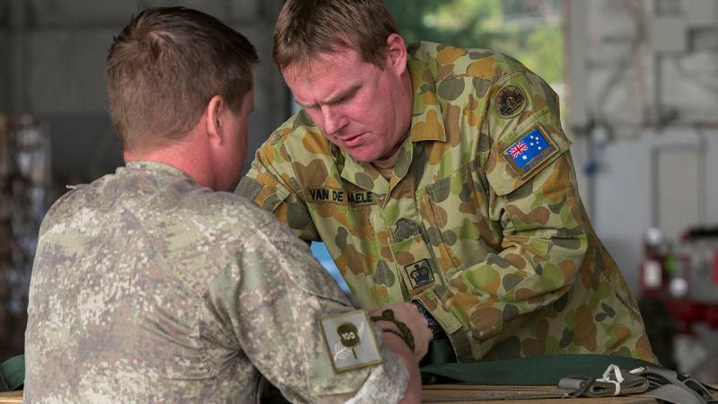 WO2 John Van De Maele and a rigger from the New Zealand Army build a container delivery system for an air drop. Photo: Corporal David Gibbs