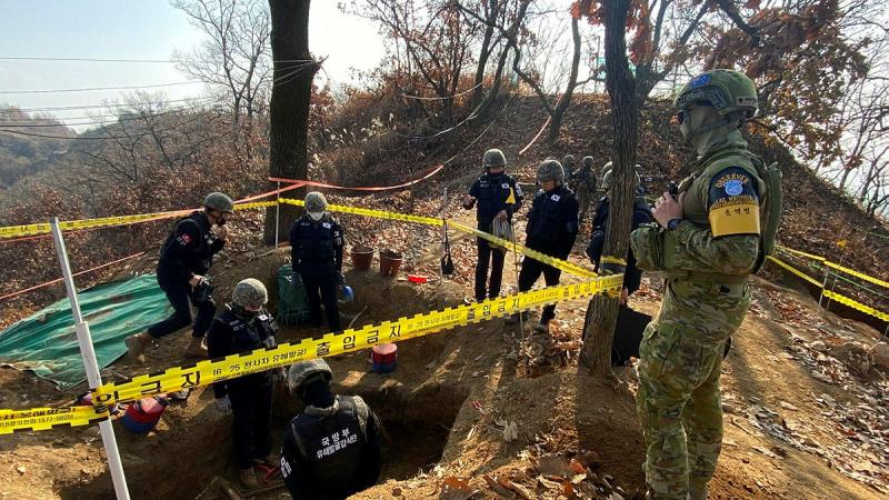 Australian observer Leading Aircraftman Ben Whitfield, right, observes personnel from the Ministry of National Defense for Killed in Action Recovery and Identification conduct human remains recovery at White Horse Hill. Photo: Petty Officer Jason Wilson