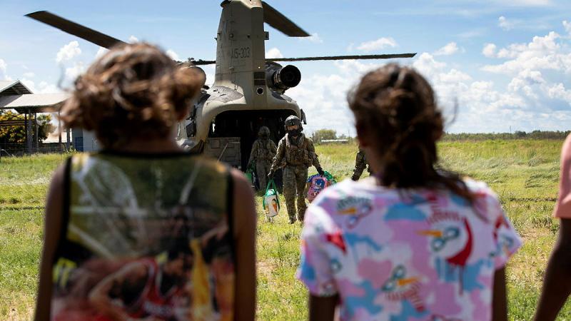Members of C Squadron, 5th Aviation Regiment unload groceries off an Australian Army CH-47 Chinook helicopter for the Yungngora people returning to their homes in Noonkanbah.