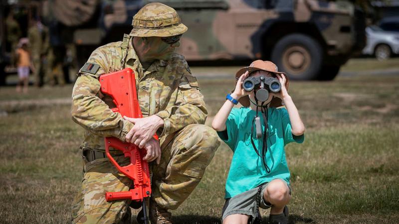 Private Wayne Drage shows a child how to use binoculars during a demonstration at Exercise Rocky Ready, at the Rockhampton Showgrounds last year. Photo: Corporal Madhur Chitnis