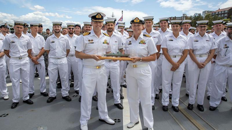 Outgoing Commanding Officer HMAS Hobart Captain Andrew Pepper, front left, hands the “weight of command” to the incoming Commanding Officer Commander Tina Brown. Photo: Petty Officer Christopher Szumlanski