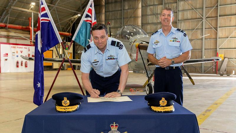 Incoming Commander Air Warfare Centre Air Commodore Adrian Maso, signs the transfer of command certificate witnessed by the outgoing Commander Air Commodore Ross Bender. Photos: Corporal David Cotton