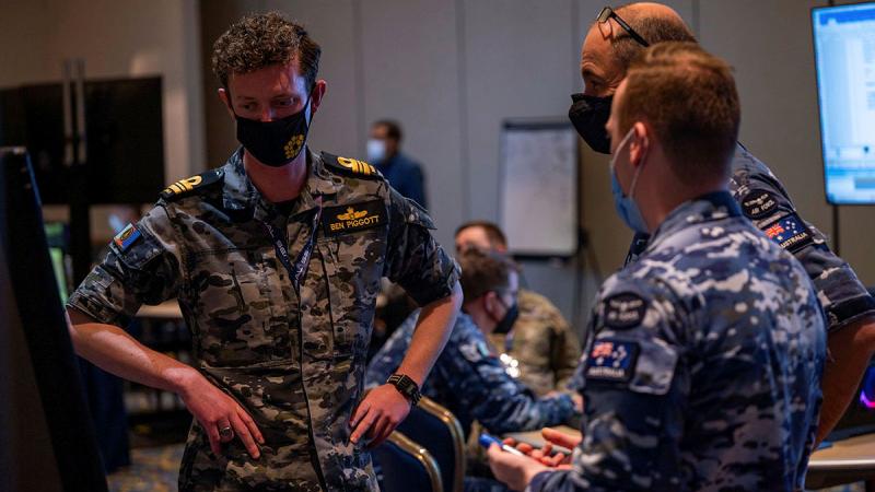 Lieutenant Commander Benjamin Piggott from Defence Space Command talking with other ADF team members on Exercise Global Sentinel 22 in California. 