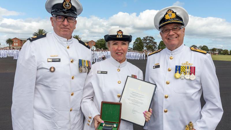 Senior Naval Officer Victoria , Commodore Greg Yorke, right, and Command Warrant Officer HMAS Cerberus, Warrant Officer Brendan Woodsell, left, present Chief Petty Officer Elaine Egan with a Federation Star, representing 40 years in the RAN. Photo: Leading Seaman James McDougall