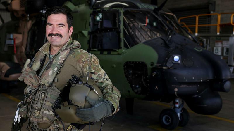 Australian Army aircrewman Sergeant Damien Collison-Bryant stands in front of an MRH-90 Taipan at Australian Army Aviation Training Centre, Swartz Barracks, Queensland. Photo: Brad Richardson