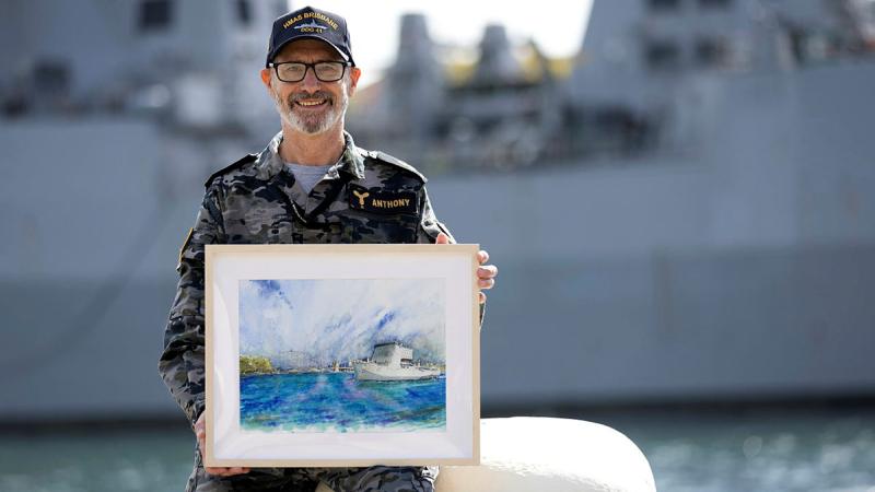 Leading Seaman Geoff Anthony displays his watercolour painting of HMAS Choules at Garden Island, Sydney. Photos: Private Nicholas Marquis