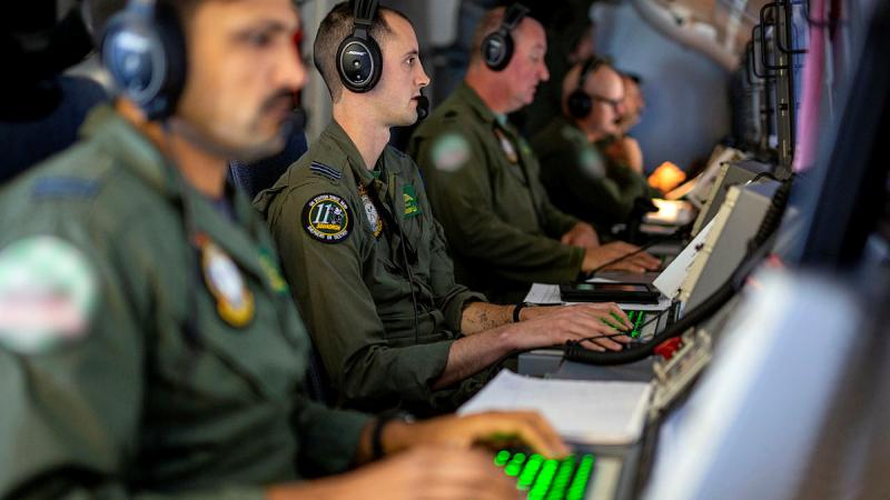 RAAF Tactical Coordinator, Flight Lieutenant Brad Jolly, centre, at his station on-board a P-8A Poseidon during Operation Argos 2023. Photo: SGT Nicci Freeman
