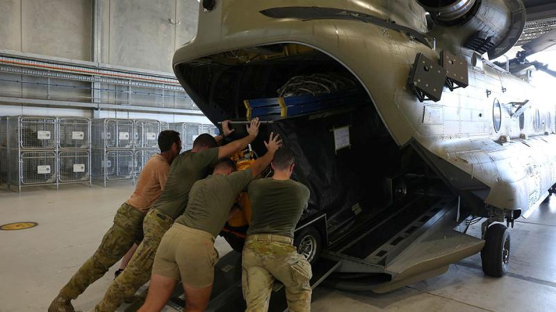Australian Army soldiers from the 5th Aviation Regiment load a flyaway toolkit aboard a CH-47 Chinook helicopter at RAAF Base Townsville ahead of its deployment to Vanuatu. Photos: Warrant Officer – Class 2 Max Bree