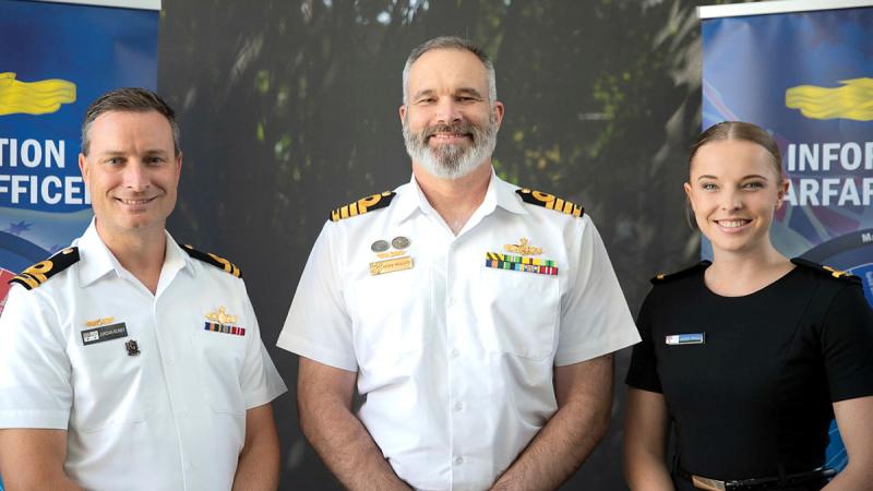 From left, information warfare officers Lieutenant Jordan Roney, Captain Andrew Macalister and Sub-Lieutenant Jacqui Meacle celebrate the work group’s first anniversary as a primary qualification. Photo: Corporal Michael Rogers 