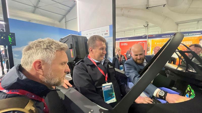 News presenter and Air Force Reservist, Wing Commander Peter Overton, centre, is pictured with Simon Hobbs, left, testing a flight simulator at Avalon Air Show. Photos: Alex Given
