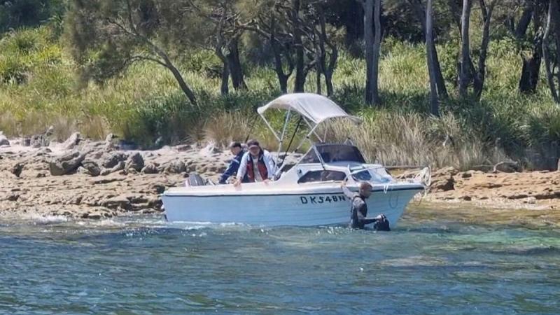 Seaman Clearance Diver Finn Bentley from HMAS Yarra assists civilian mariners after they became lodged on a reef near Murray's Beach, Jervis Bay. 