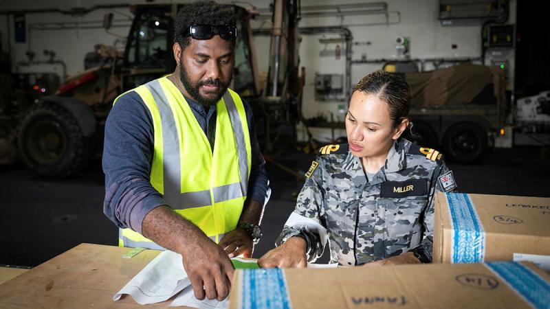 Greg Willie, co-leader of logistics and procurement under the National Health Emergency Operation Committee and Lieutenant Donna Miller organise goods and cargo on board HMAS Canberra in support of Operation Vanuatu Assist. Photo: Leading Seaman Matthew Lyall