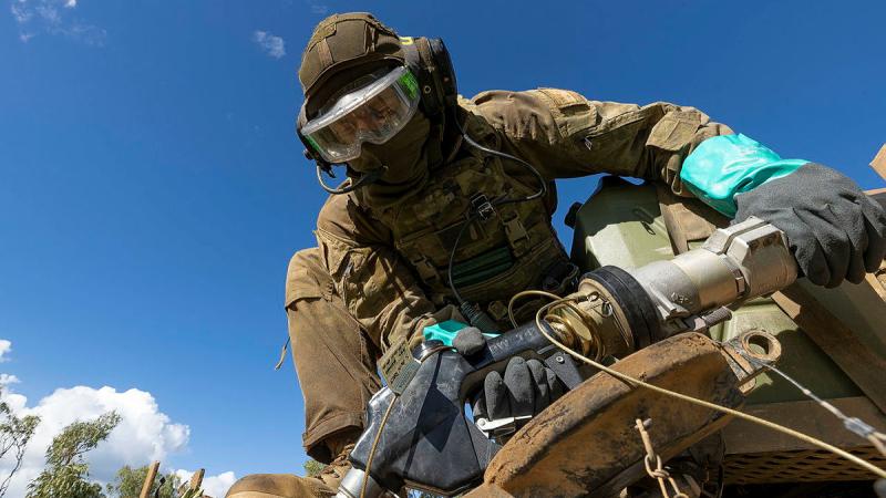 A soldier from the 2nd Cavalry Regiment conducts a refuel on the M1 Abrams Main Battle Tank during Exercise Eagle Walk. Photos: Lance Corporal Riley Blennerhassett