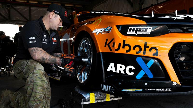 Warrant Officer Class Two Luke Parlor, a mechanic from Defence Force School of Signals conducts maintenance on a V8 Supercar at the Australian Formula 1 Grand Prix in Melbourne. Photo: Leading Aircraftwoman Taylor Anderson