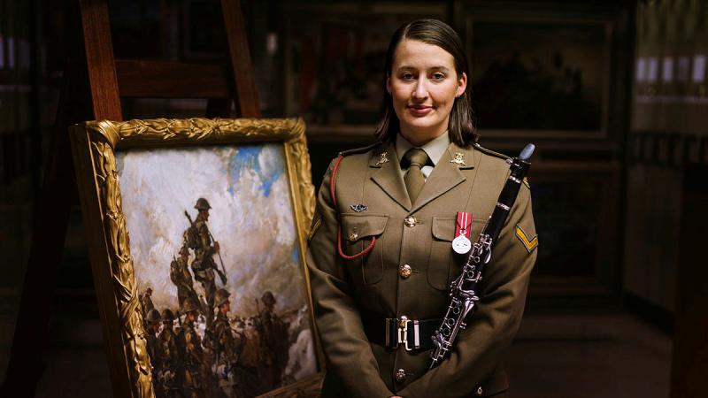  Australian Army Band member Lance Corporal Lenore Evans with a painting by her great-great-great-uncle, war artist Private Frank Crozier, who served at Gallipoli and in France. The painting is held by the Australian War Memorial at the Treloar Technology Centre in Canberra. Photos: Sergeant Oliver Carter