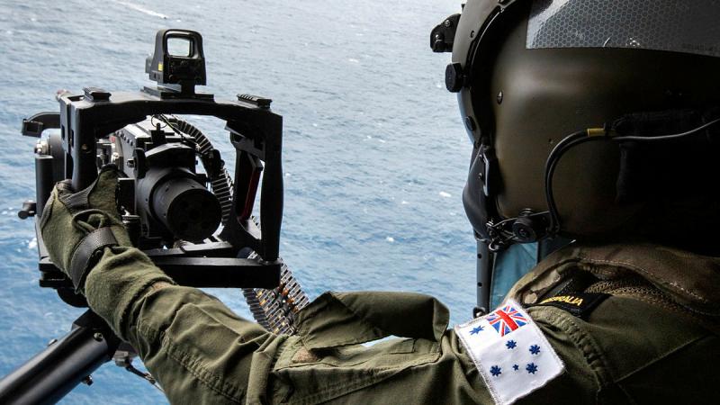 Leading Seaman Aircrewman Belinda Cole operates the 50 Calibre machine gun from the door of a MH-60R during Exercise Tigerfish. Photo: Petty Officer Justin Brown