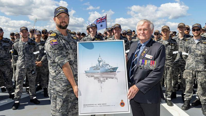 Commanding Officer HMAS Toowoomba Commander Darin MacDonald, left, receives a painting gift from the Western Australian Naval Association President Ian Holthouse during a clear lower deck on board the ship at HMAS Stirling. Photo: Leading Seaman Ernesto Sanchez