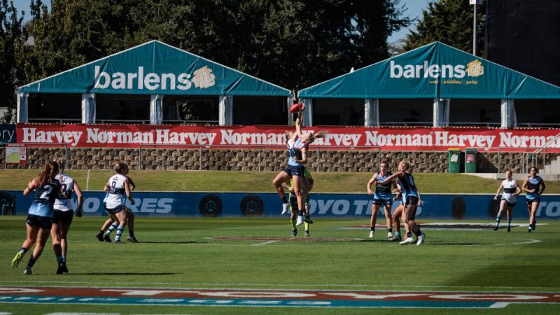 ADF Women's All Stars ruck, Celine Moody, contests the centre bounce during the curtain-raiser game against the NSW Police Blue Heelers as part of the AFL Anzac Round at Manuka Oval, Canberra. Photos: Corporal Lisa Sherman