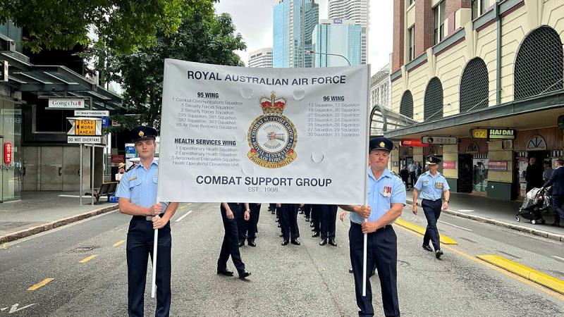Combat Support Group aviators march behind banner celebrating their 25th Birthday this year. Photo: Warrant Officer Anthony Hartley