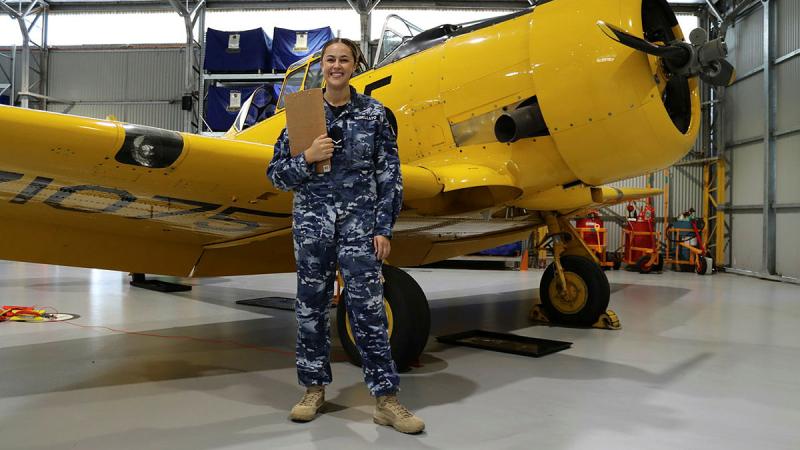 Leading Aircraftwoman Casey-Lee Rebellato in front of a Harvard aircraft at RAAF Base Point Cook. Photo: David Jones