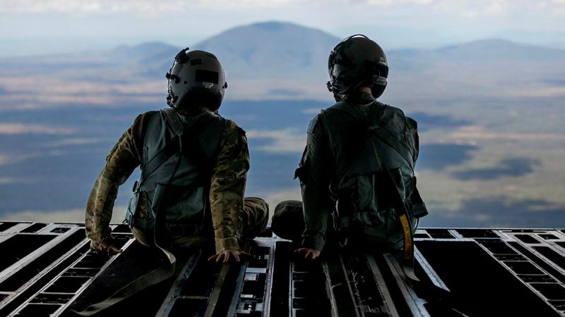 RAAF and US Air Force loadmasters sit on the ramp of a 36 Squadron C-17A Globemaster III during a low level navigation sortie in North Queensland. Photo: Corporal Kieren Whitely