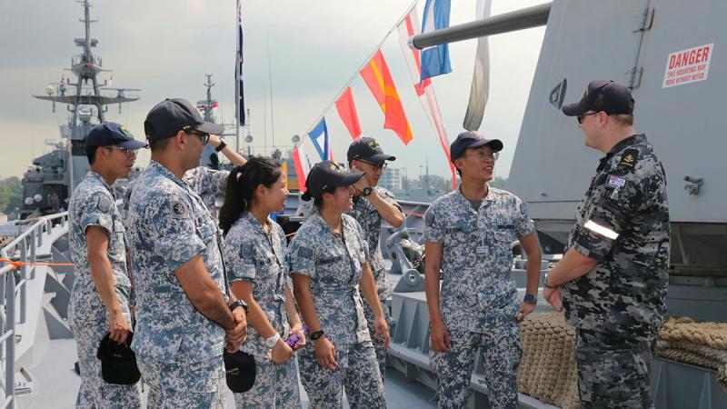 Leading Seaman Cory Duggan gives a tour to Singapore Navy personnel on board HMAS Toowoomba.