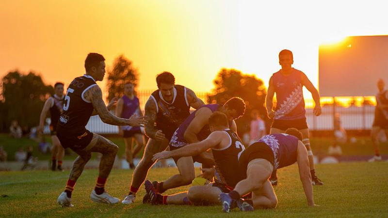 Players from the men's ADF and NT Police, Fire and Emergency Services teams scuffle for the ball during the Anzac Shield charity Australian rules match in Darwin. Photo: Signaller Kobi Rankin