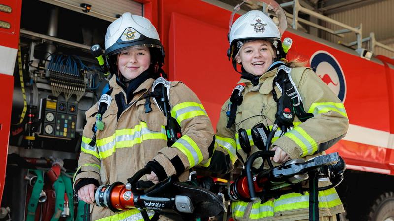 Air Force Aviation Programs for Young Woman participants try on firefighting equipment at RAAF Base Williamtown. Photo: LAC Samuel Miller
