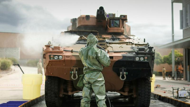 Australian Army sappers from the 2nd Combat Engineer Regiment hose down a Boxer Combat Reconnaissance Vehicle in a decontamination bay. Photo: Sapper Tristan Montagu