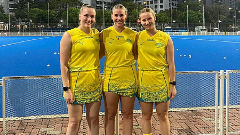 Flying Officer Riley Smith, right, at the Singapore Sports Hub with NSW Country hockey players Clare Bosman and Millie Leard. Photo: Flying Officer Riley Smith