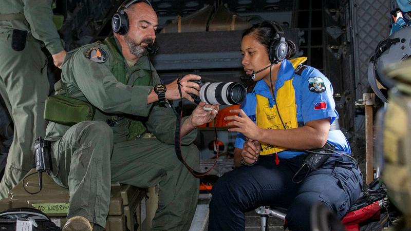 Loadmaster Flight Sergeant Christian Allison of 35SQN teaches Samoan police officer Constable Fetuao Nuuvali how to use the camera during Operation Solania. Photos: LAC Chris Tsakisiris