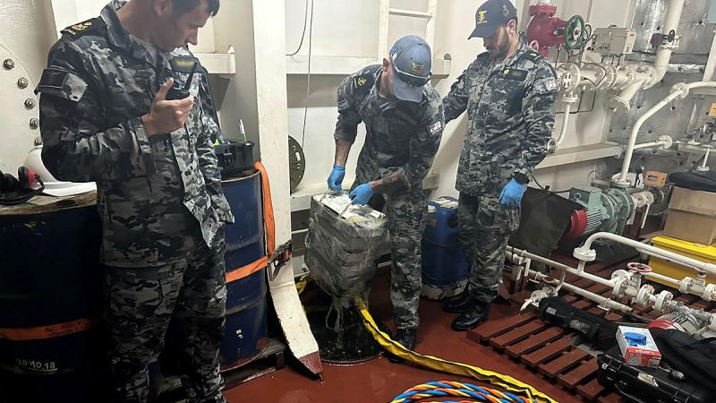 Navy clearance divers extract packages of cocaine found during a confined spaces dive inside a flooded ballast tank in the bulk carrier MV St Pinot while supporting law enforcement agencies. 