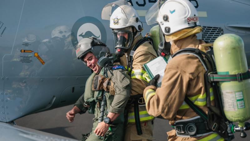 Air Force fire fighters evacuate a simulated casualty from a PC-21 aircraft during a crash exercise at RAAF Base Williamtown, NSW. Photos: Leading Aircraftman Samuel Miller
