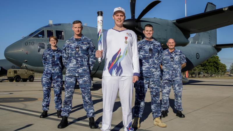 Legacy Centenary Torch Relay Bearer Nicholas Paske (Centre) with Air Force personnel (L-R) Leading Aircraftwoman Sarah Negrin, Warrant Officer Scott Biddell, Flight Lieutenant Brett Smith and Flight Sergeant Shawn Spry in front of a C-27J Spartan at RAAF Base Amberley, QLD. Photo: Leading Aircraftwoman Taylor Anderson