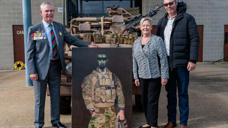 Mr Doug Baird, Mrs Kaye Baird and Mr Brendan Baird with a painting of  Australian Army soldier Corporal Cameron Baird, VC, MG