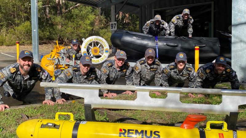 Navy personnel conduct push-ups among deployable survey team equipment