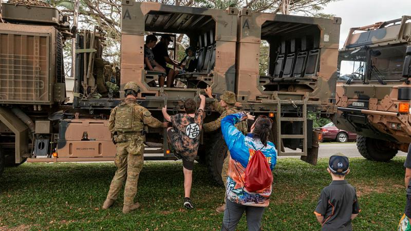 Australian Army soldiers from Battle Group Ram assist evacuee role-players into an HX-77 during a simulated non-combatant evacuation operation during Exercise Diamond Strike. Photo: Corporal Nicole Dorrett