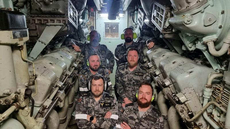 Marine engineering training & engineering operator remediation plan (Plan METEOR) students and staff in the diesel engine enclosure of HMAS Perth.