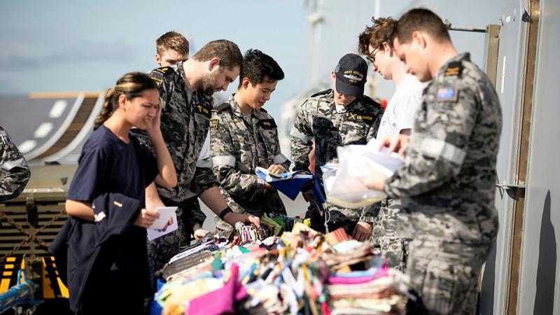 ADF members choose a new Aussie Hero Quilts dhoby bag during HMAS Adelaide's transit to North Queensland. Photos: Petty Officer Craig Walton
