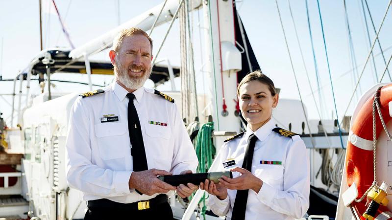 Out-going Commanding Officer (CO) Sail Training Ship (STS) Young Endeavour, Lieutenant Commander Adam Farley, left, hands over the "Weight" to in-coming CO, Lieutenant Commander Elizabeth Newman, the first female CO of STS Young Endeavour in its 35-year history. Photo: Leading Seaman David Cox