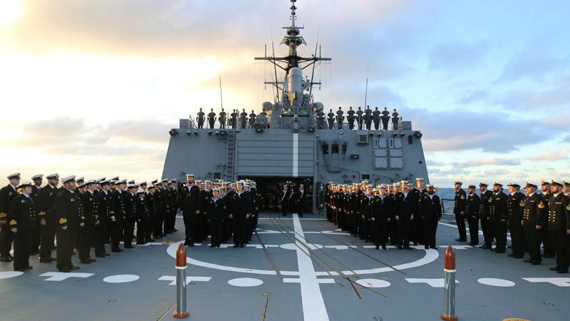 HMAS Sydney (V) Ship's Company stand at attention to honour the loss of HMAS Sydney (II) and HSK Kormoran.