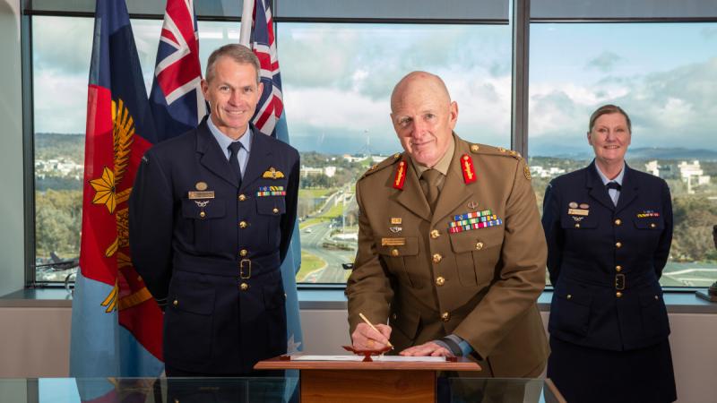 Chief of Joint Capabilities Lieutenant General John Frewen signs the Change in Command of Space Command document in front of Chief of Air Force Air Marshal Robert Chipman and Commander Defence Space Command Air Vice Marshal Cath Roberts. Photo: SGT Rodney Welch