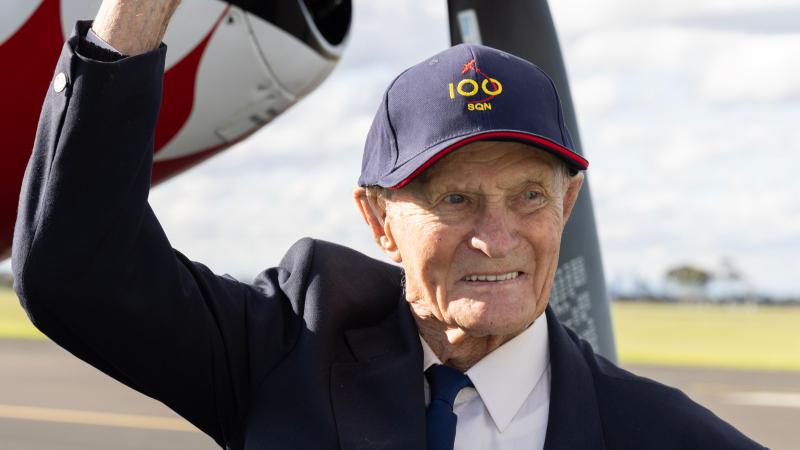Squadron Leader Ted McConchie (Ret'd) smiles in front of a CAC CA-18 Mustang