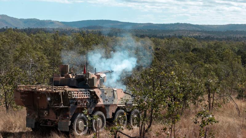 An Australian Army Boxer Combat Reconnaissance Vehicle live fires in the Australian bush.