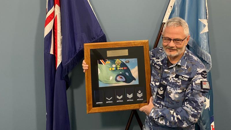 Flight Sergeant Stephen Olding with his presentation gift to mark his retirement from the RAAF