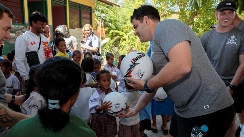 An Australian Army Football Northern Territory team member, gives a soccer ball to a child from the Santa Teresinha school in Liquiçá, Timor-Leste, during Indo-Pacific Endeavour 2023.