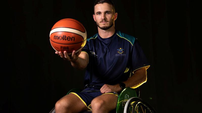 Able Seaman Cooper Blackwood poses for a photo while holding a basketball.