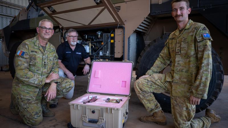  Project Manager for Land 2072 Phase 2B Lieutenant Colonel Matthew Kitchin, Project lead Mr Dafydd Gwynn-Jones and Signaller Harry Saunders, stand in front of the new 'Protected Mobility Headquarters on the Move' Bushmaster variant at the 1st Combat Signals Regiment in Darwin, NT.