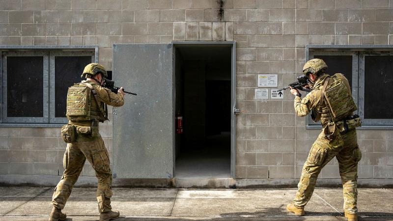 From left, Army soldiers Lance Corporal Timothy Maloney and Private Liam McIvor, from the 9th Battalion, Royal Queensland Regiment, prepare to enter a building at Gallipoli Barracks, Queensland. 